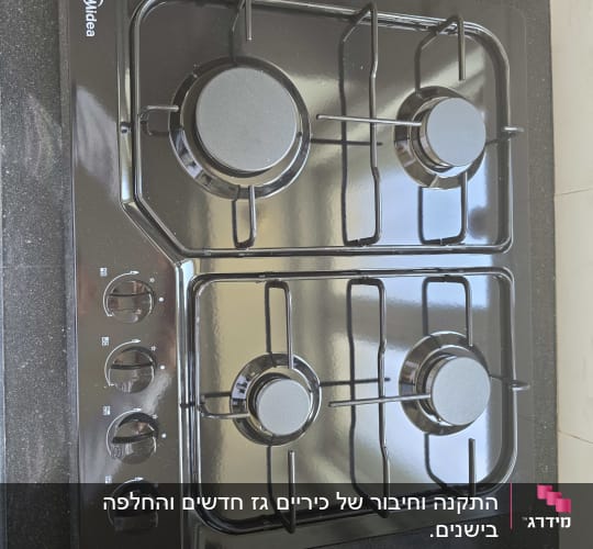 כיריים גז שחורות עם ארבעה מבערים וכפתורי שליטה